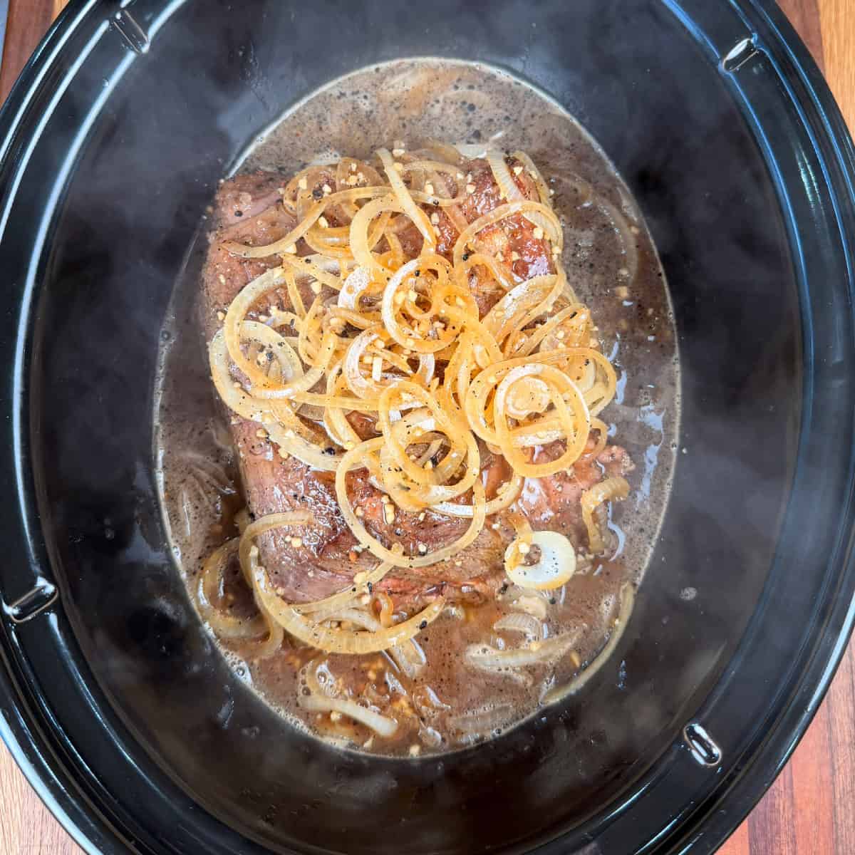 Chuck roast with onions and gravy in slow cooker