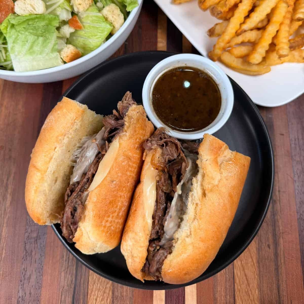 French Dip sandwiches plated with fries and salad