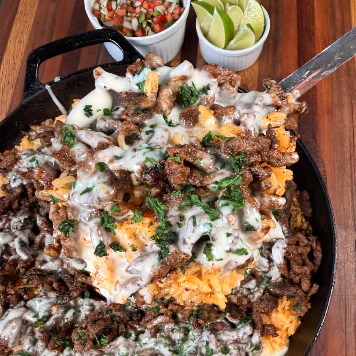 Scoop up of Steak cheese and Rice on a spoon with Pico de Gallo and lime slices