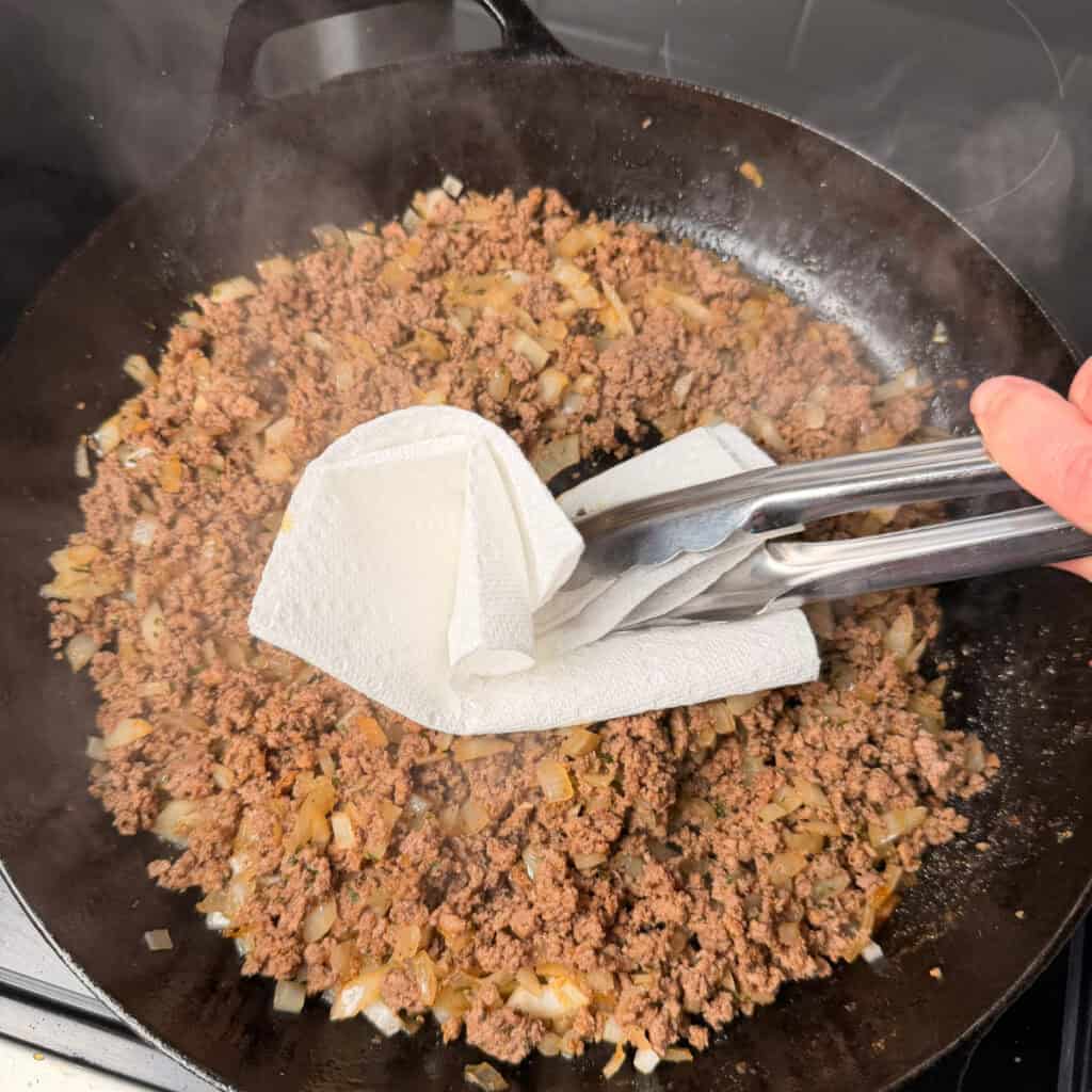 draining the grease from the beef with a paper towel