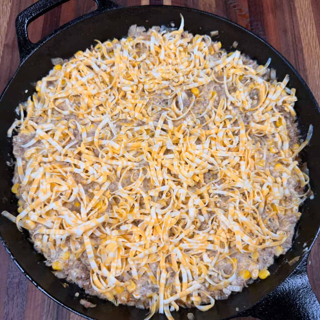 unbaked casserole topped with cheese