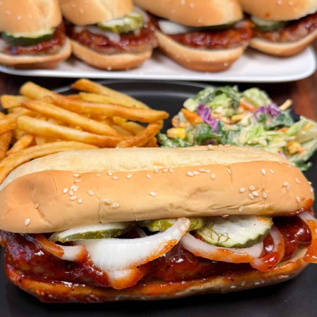 Homemade McRib Sandwich on seeded hoagie rolls with onions and pickles.