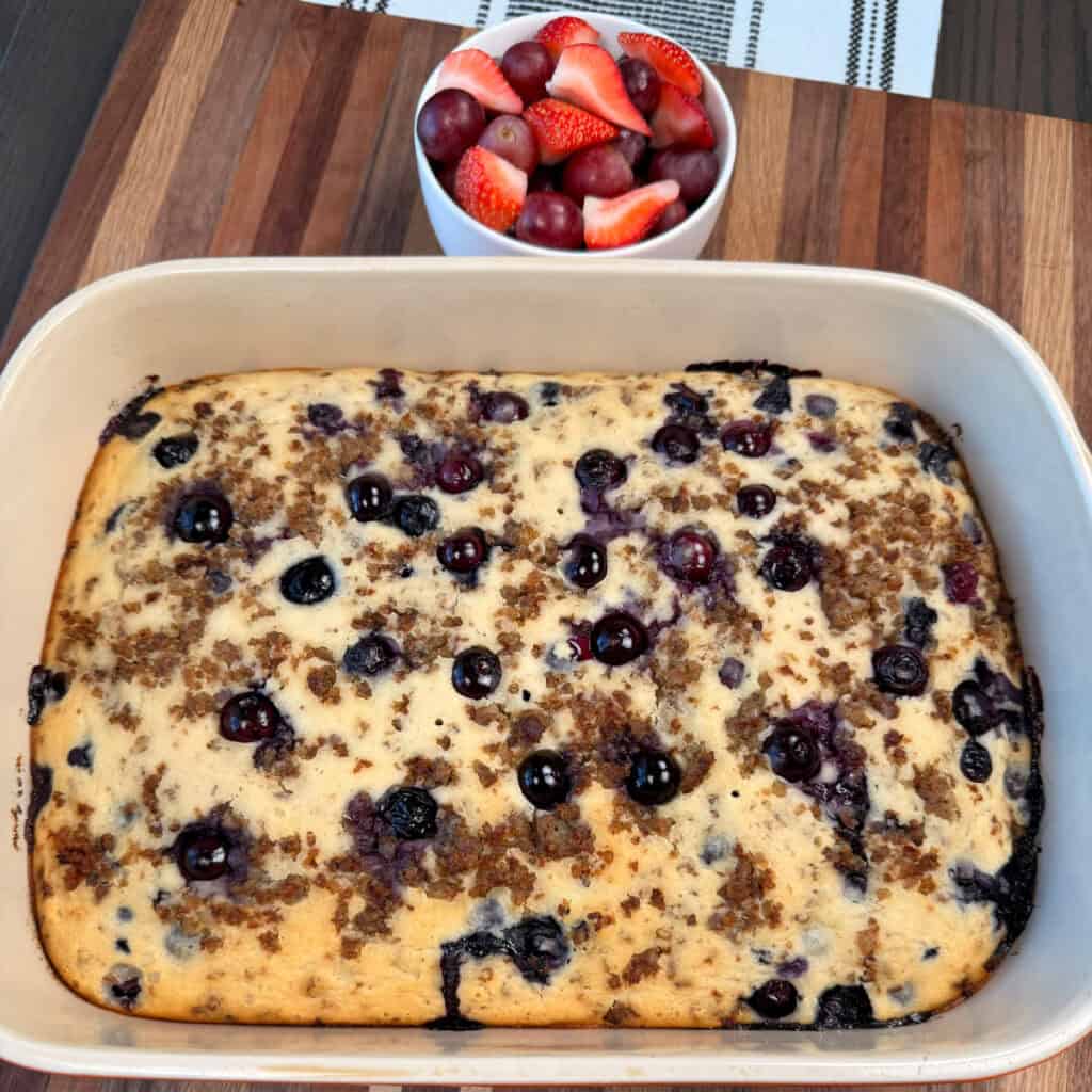Finished Blueberry Sausage Pancake Casserole with a bowl of grapes and strawberries