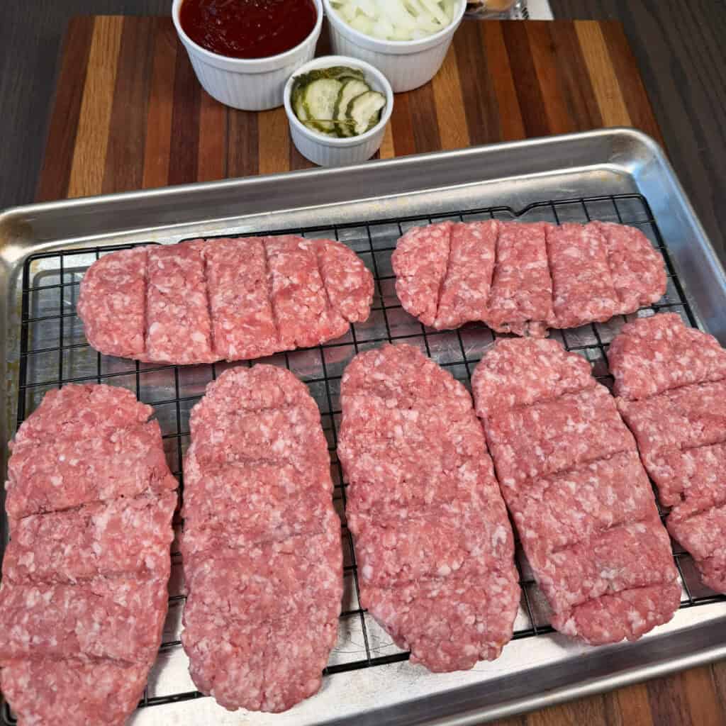Uncooked McRibs on a baking sheet with a wire rack