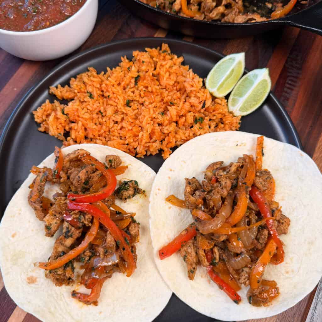 Plated Chicken Fajitas with rice and limes