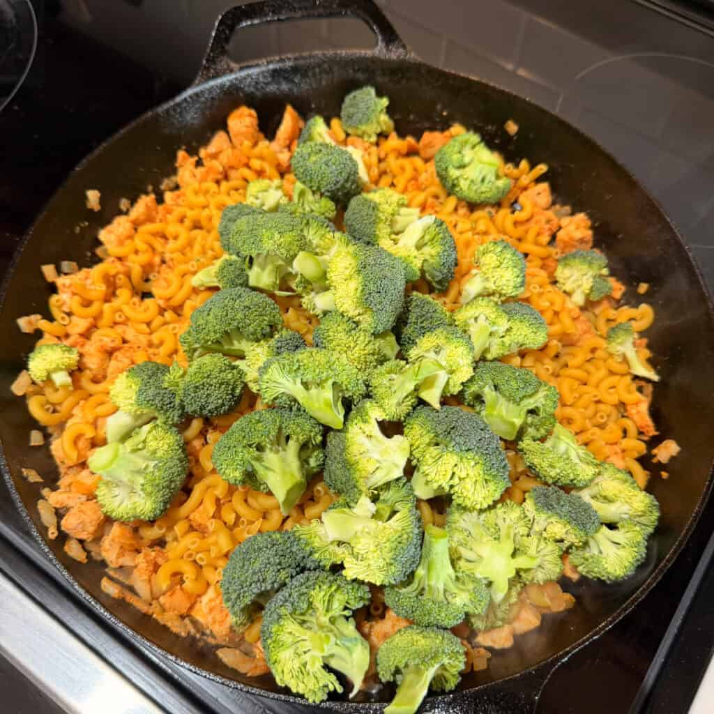 Skillet with elbow macaroni and broccoli added