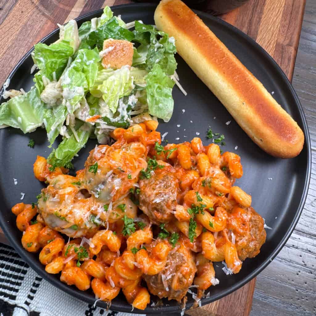 Plated Meatball Pasta, salad, and breadstick