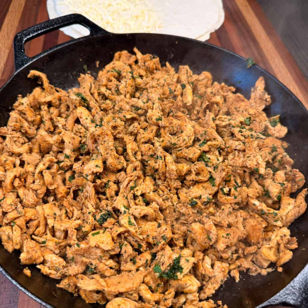 Cooked chicken in cast iron with tortillas