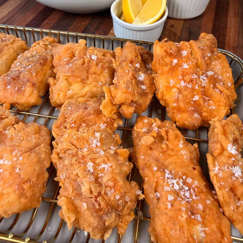 Crispy golden fish topped with salt on a wire wrack