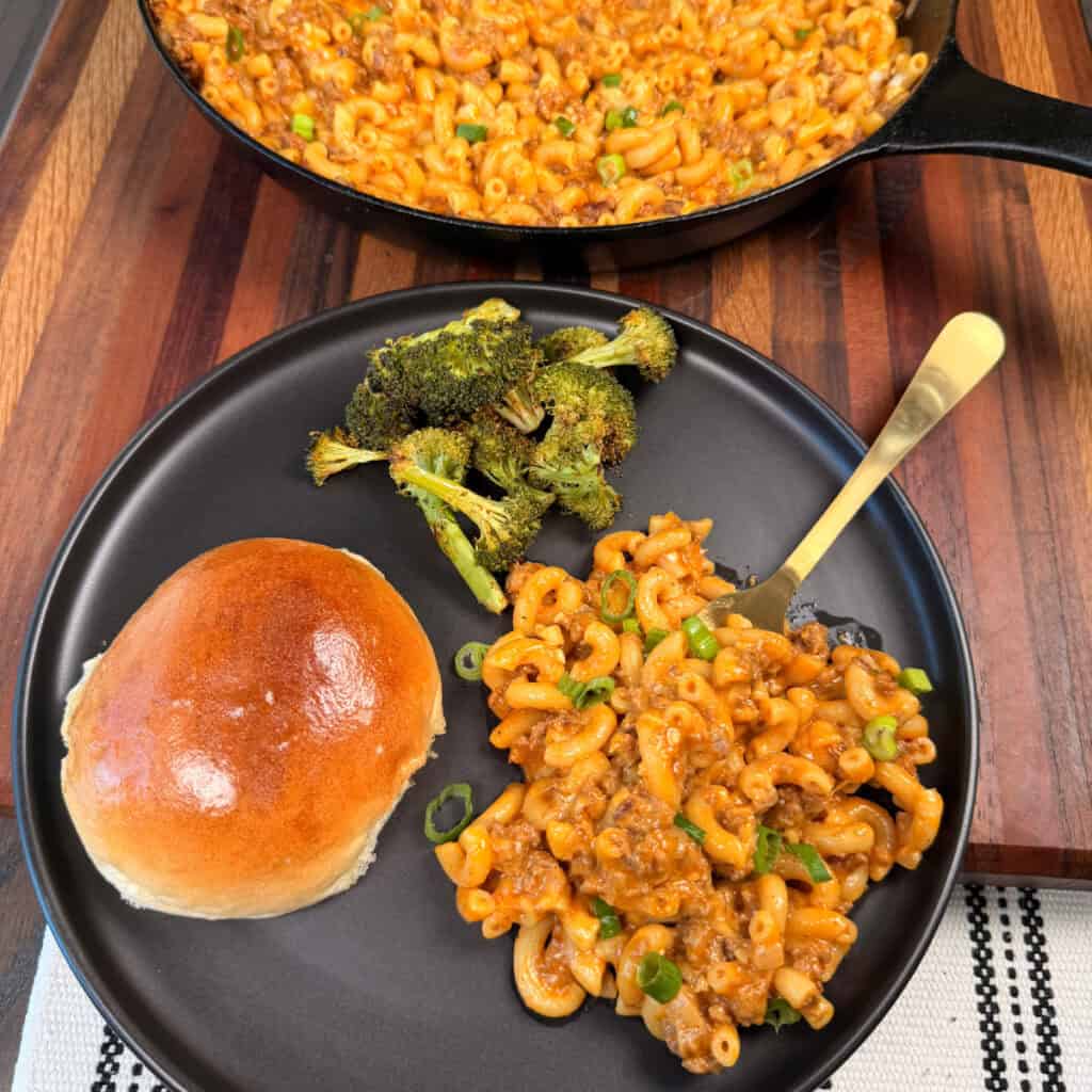 Plated Cheeseburger Mac with roasted broccoli and a roll