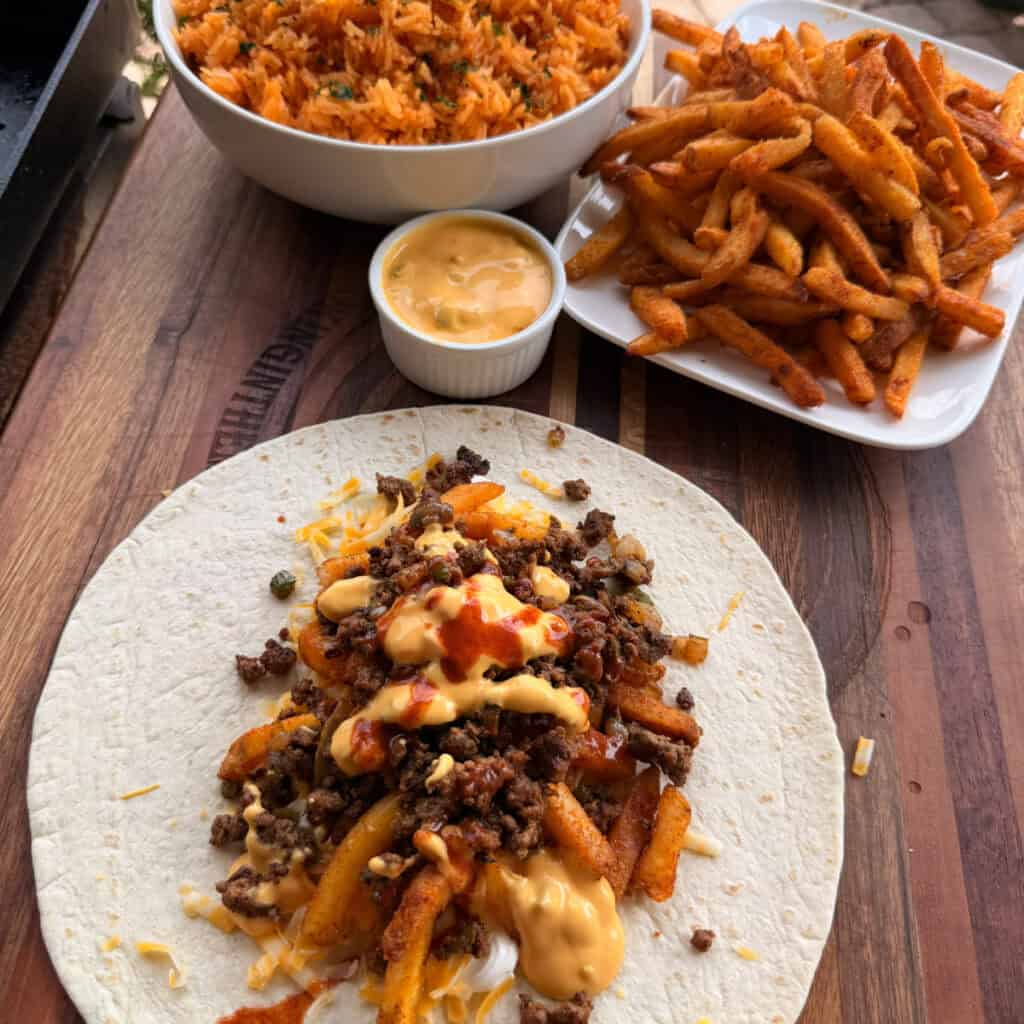 Loaded Fry Burrito being made on a tortilla