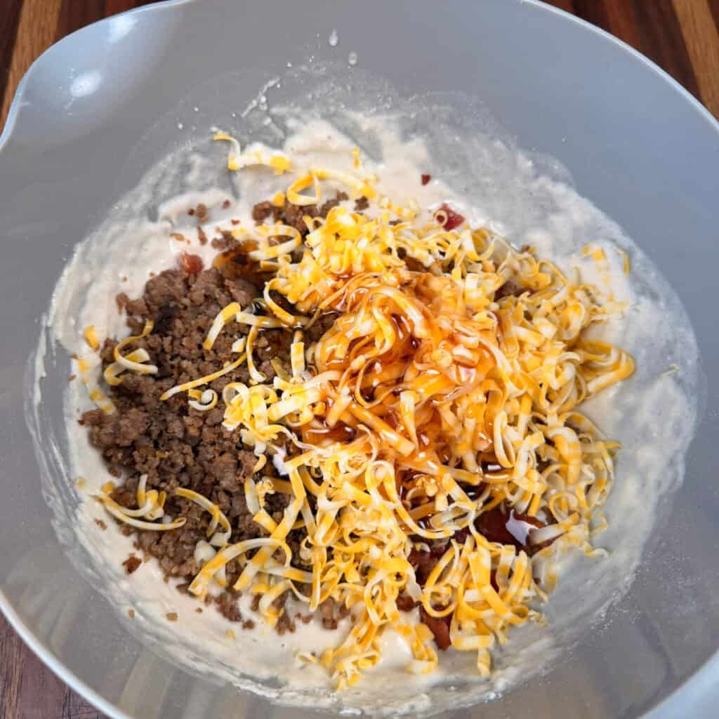 Pancake Mix, bacon, sausage, cheese, and syrup in a bowl