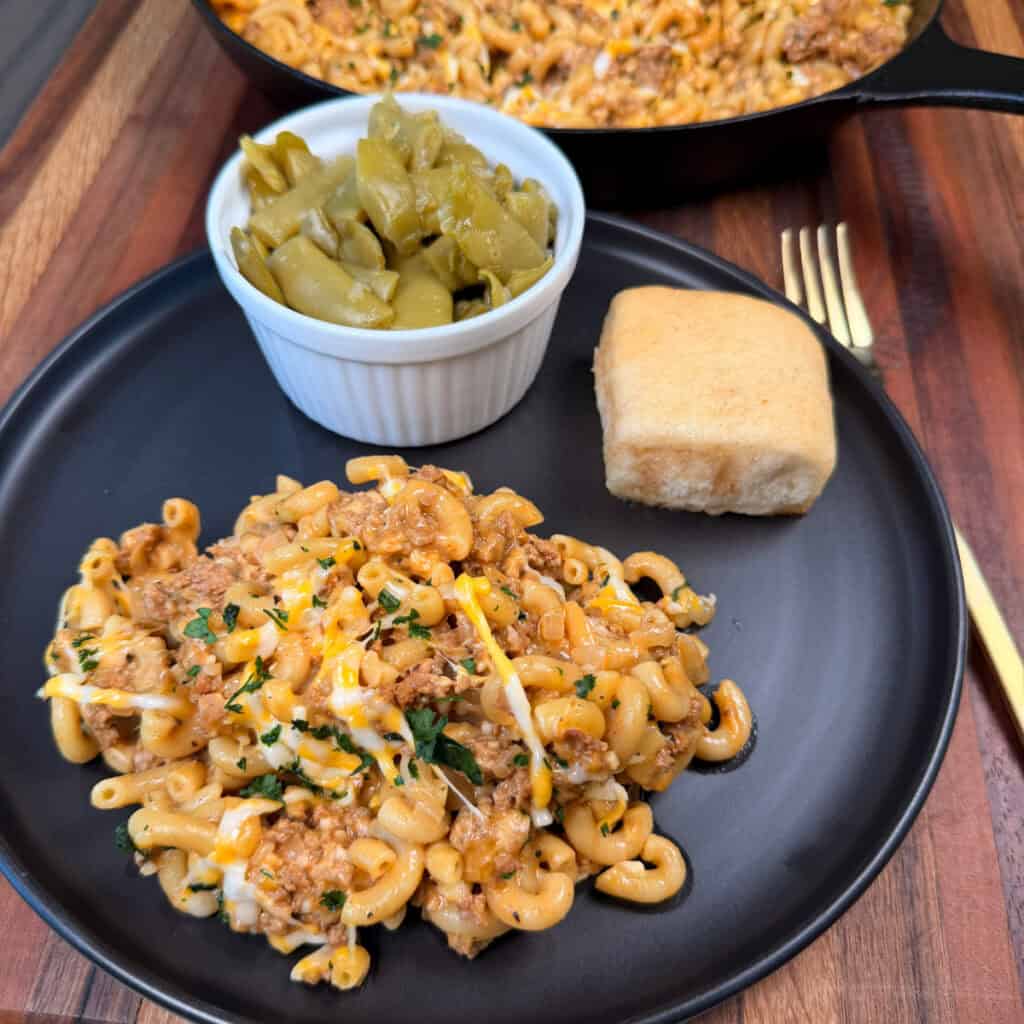 Plated Cheeseburger Mac with a roll and green beans