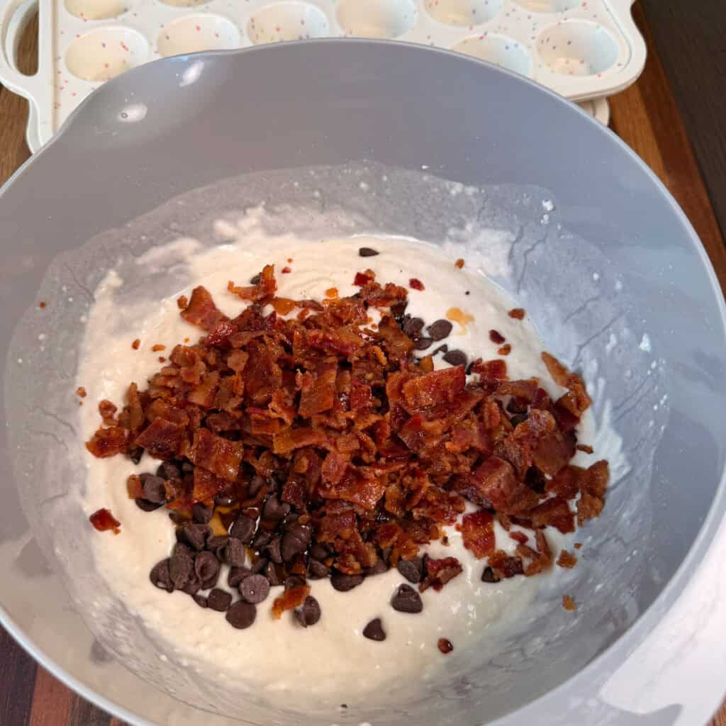 Pancake mix in bowl with chocolate chips and bacon