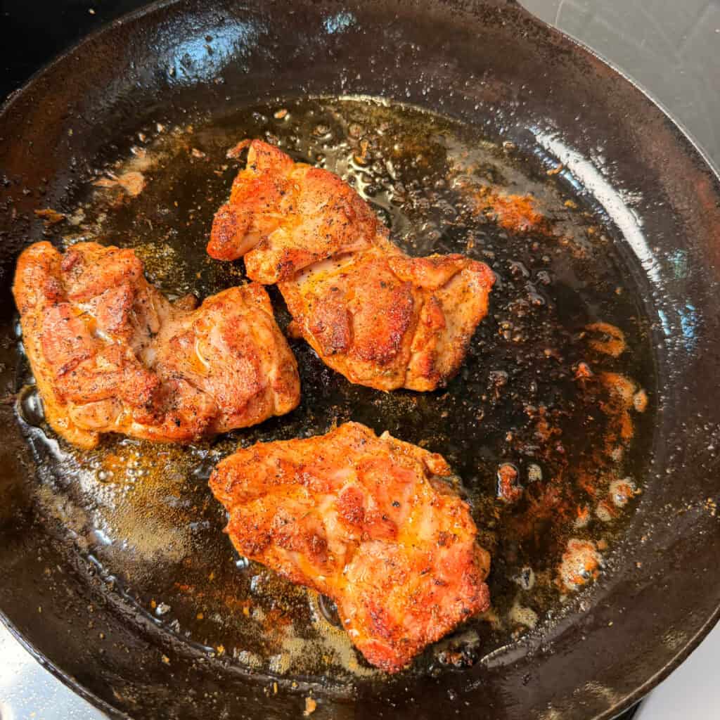 Seared chicken thighs in skillet