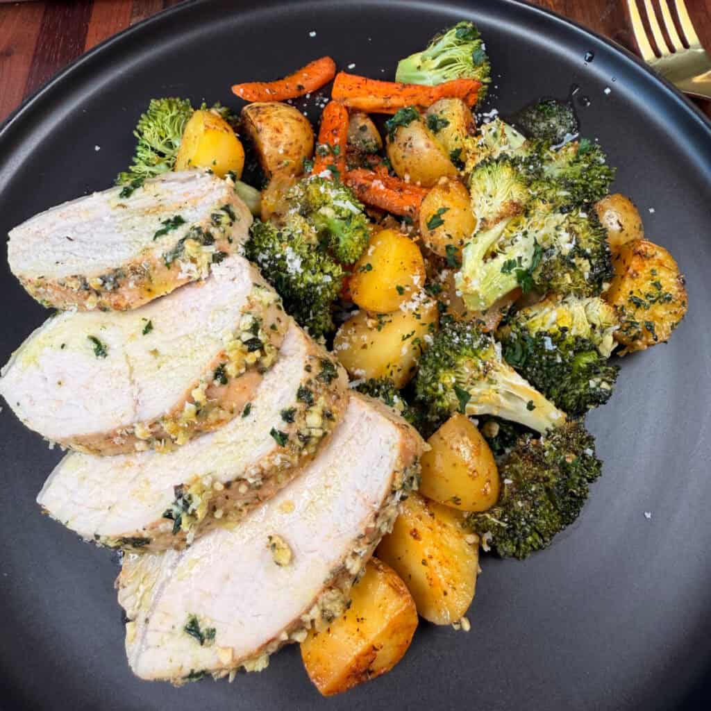 Plated Garlic Butter Pork Tenderloin and vegetables with Parmesan Cheese