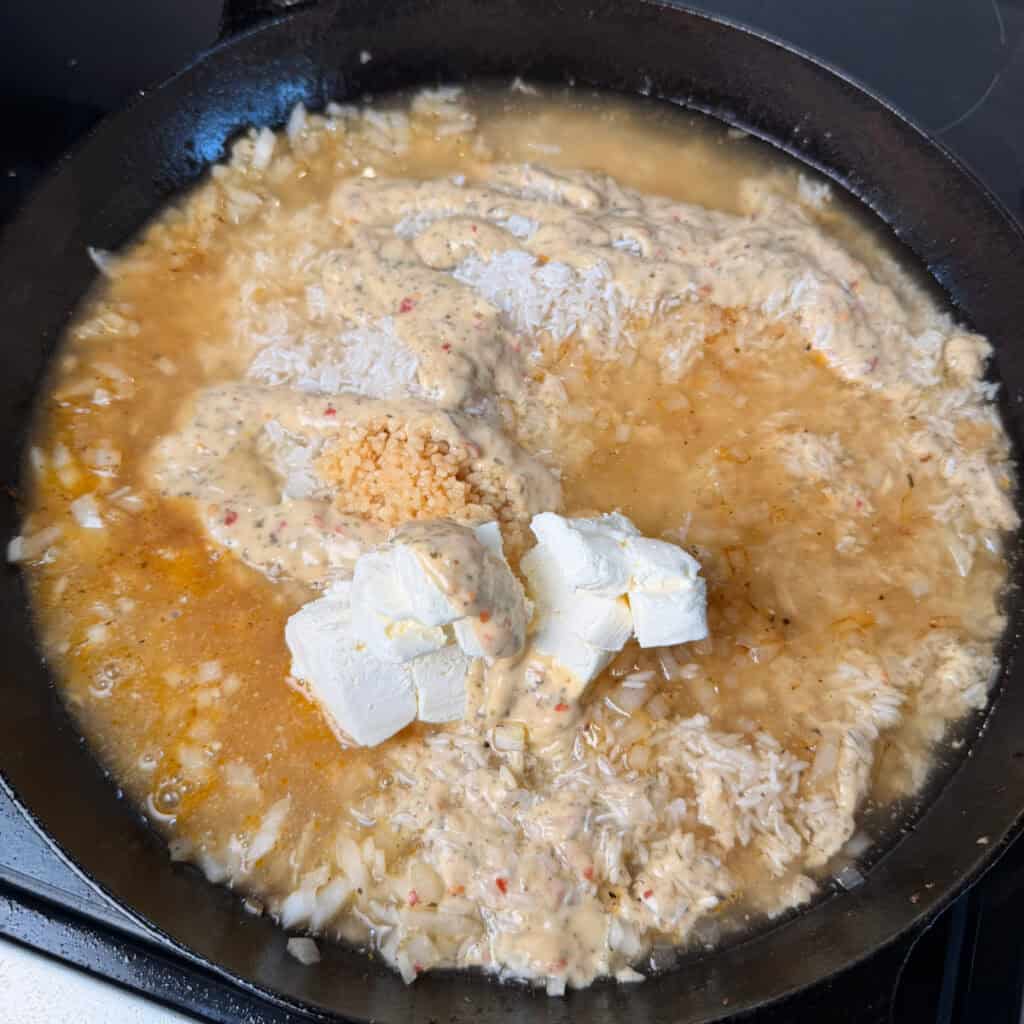 Skillet of rice, onions, broth, cream cheese, Parmesan garlic sauce
