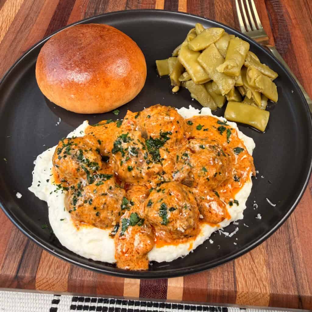 Plated Meatballs, mashed potatoes, green beans, and roll