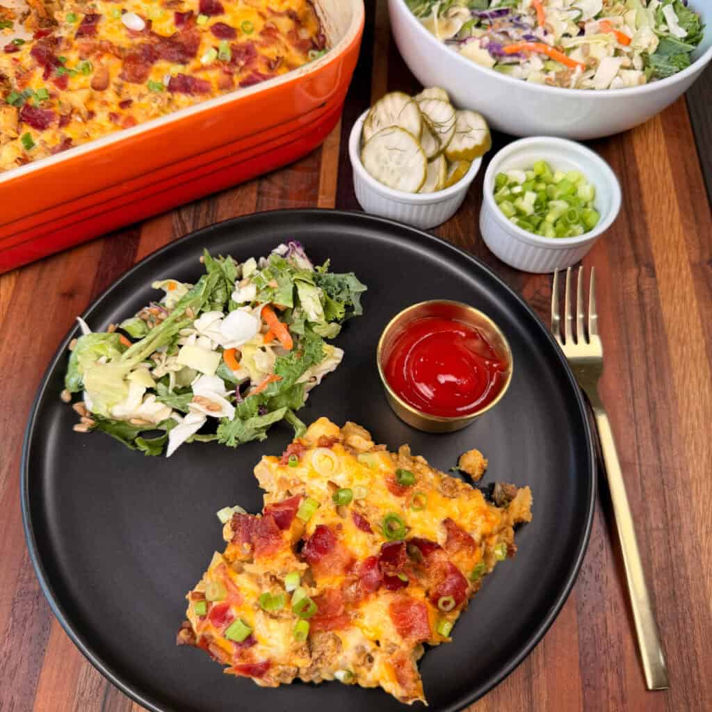 Cheeseburger Potato Casserole plated with salad and ketchup