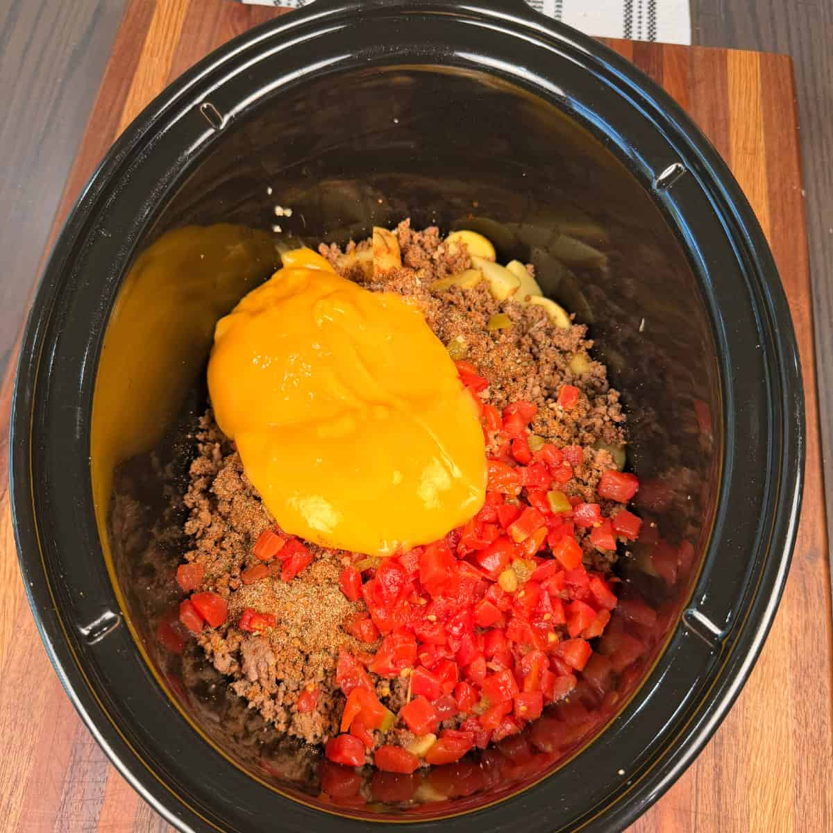 Baby potatoes, ground beef, Rotel, and Cheddar cheese soup in crockpot