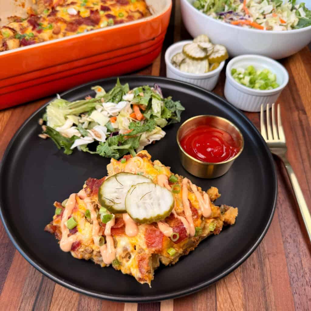 Cheeseburger Potato Casserole topped with burger sauce and pickles