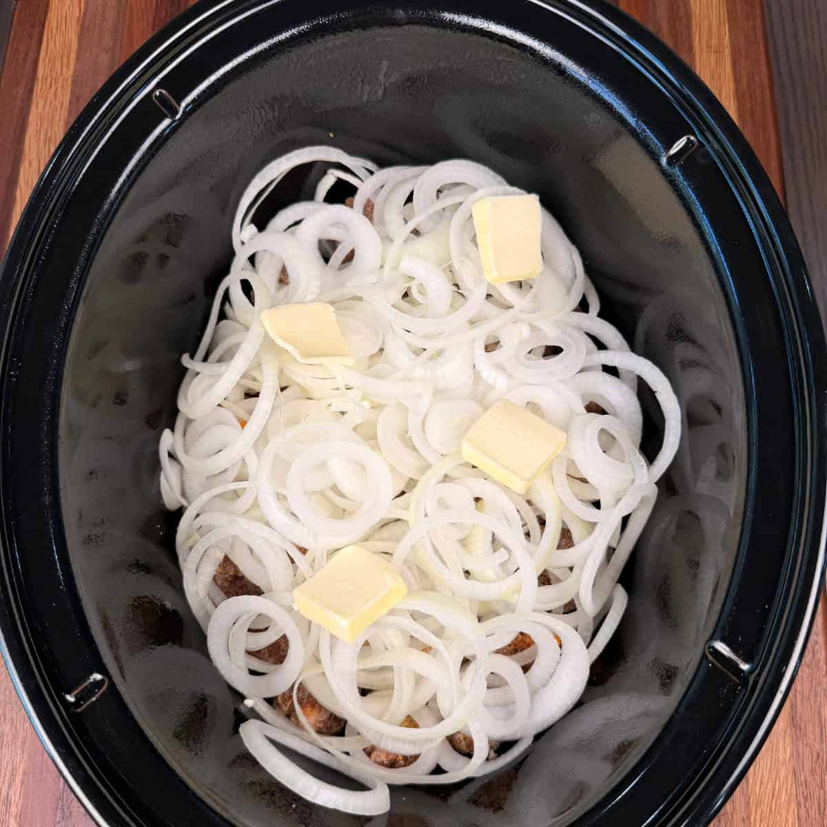 Meatballs, onions, and butter in crockpot
