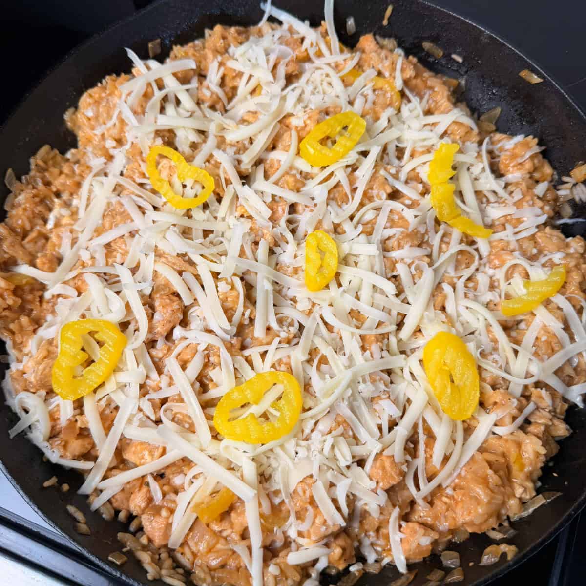 Mississippi Chicken and Rice topped with shredded mozzarella cheese and banana pepper rings