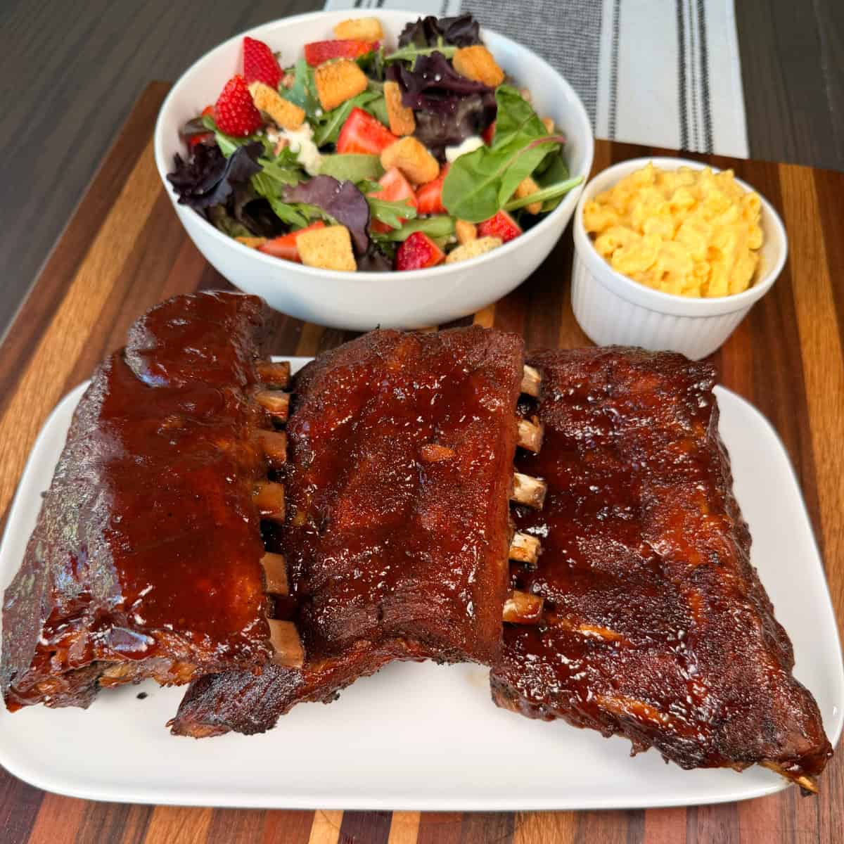 Crockpot Pork Ribs with BBQ sauce on them with salad and macaroni and cheese