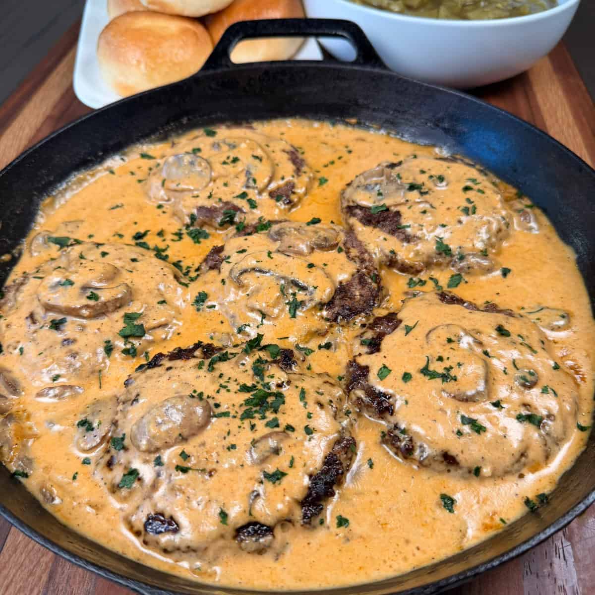 Smothered Hamburger Steaks in Mushroom Gravy in a cast iron skillet