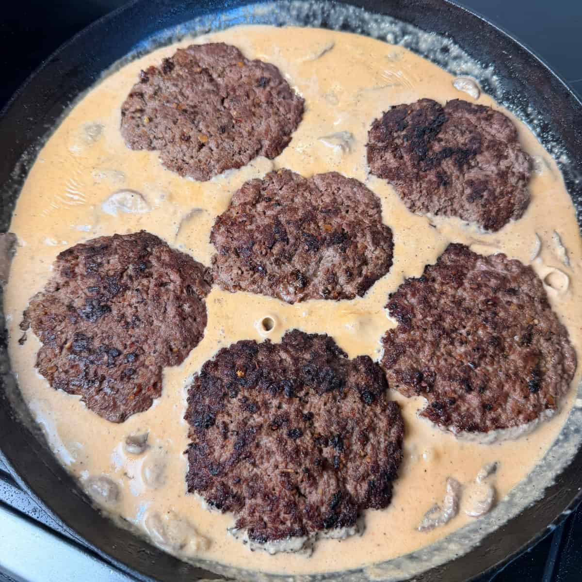 Hamburger Steaks in Mushroom Gravy in Cast iron skillet