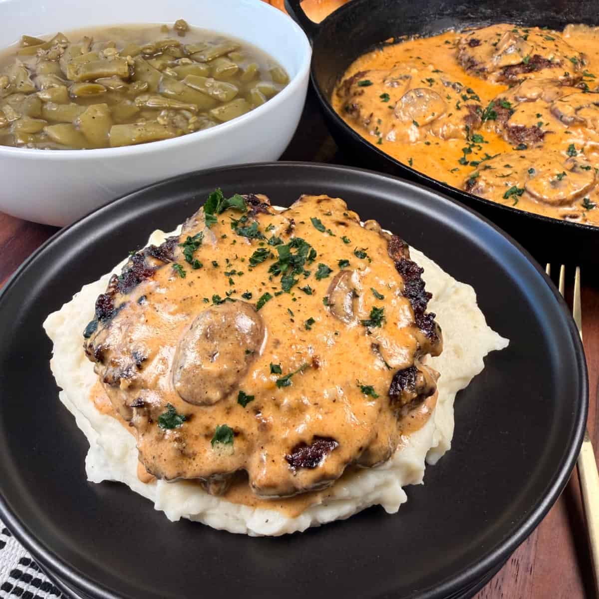 Hamburger Steaks with Mushroom Gravy plated with mashed potatoes and green beans