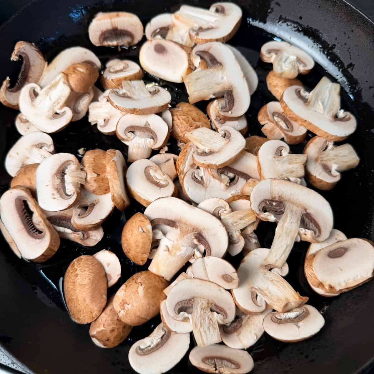 uncooked mushrooms in cast iron skillet