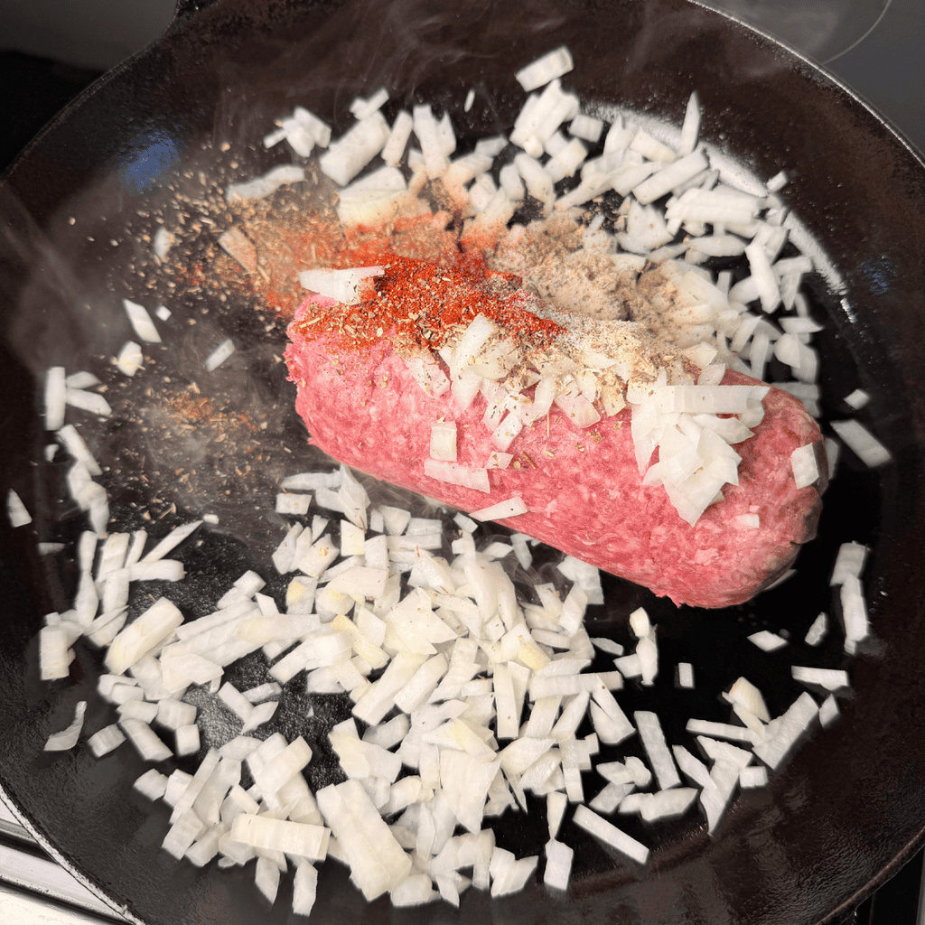 Ground beef, onions, seasoning in cast iron skillet